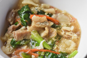 Stir-fried noodles with pork and kale, served with pork on top. Chinese-Thai food, called 