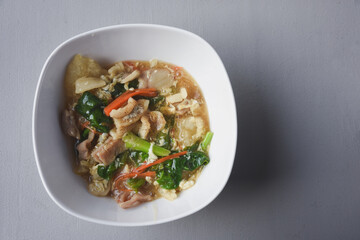 Stir-fried noodles with pork and kale, served with pork on top. Chinese-Thai food, called 
