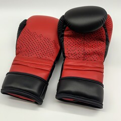 A pair of red boxing gloves with perforated design and black accents, ideal for training and competitions.