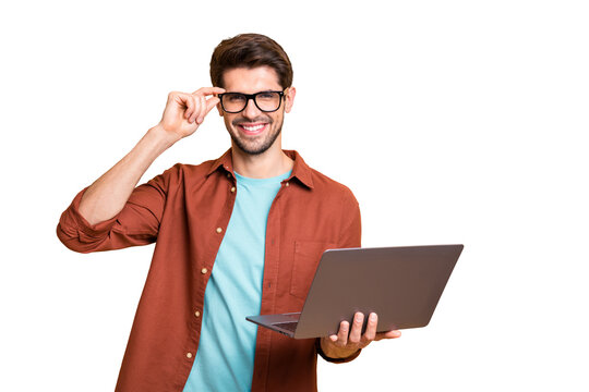 Portrait of his he nice attractive cheerful cheery successful content brunette guy holding in hands laptop working part-time touching specs isolated over beige color pastel background