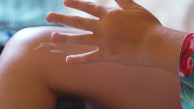 Teenage girl applies sunscreen to her body and face. 
