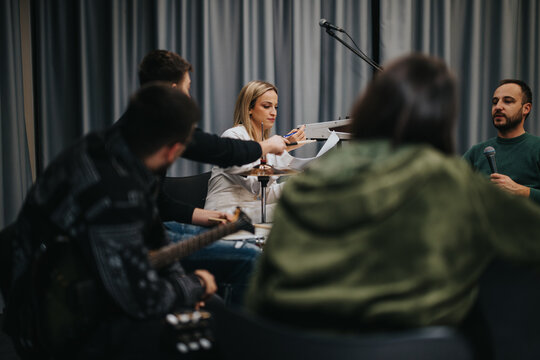 Group of musicians rehearsing together in a studio, preparing for a performance or creative project. Engaging scene of teamwork with instruments, microphones, and collaboration.