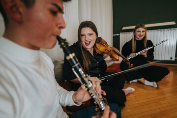 Fototapeta premium A cheerful group of young musicians collaborating and playing their instruments indoors.