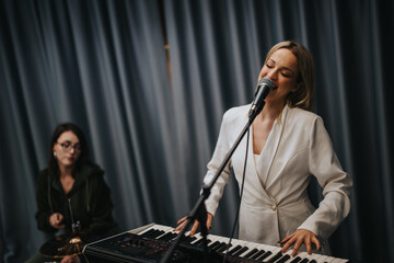 An enthusiastic duo creating music in a professional studio setup, showcasing vocal and instrumental coordination.