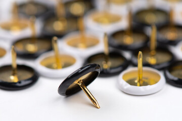 Set of metal pushpins, white background, close-up photo.