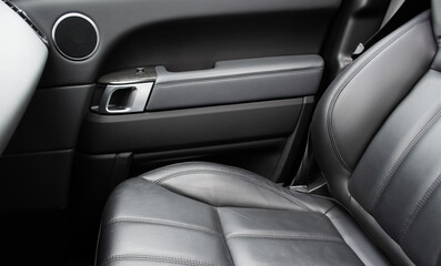 Car black leather interior. Part of black leather car seat details with white stitching. Interior...