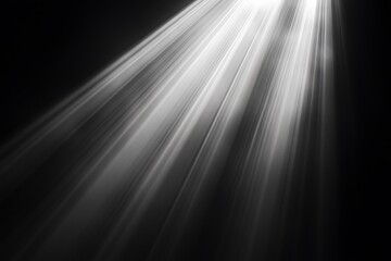 Bright light rays shining from above on black background.
