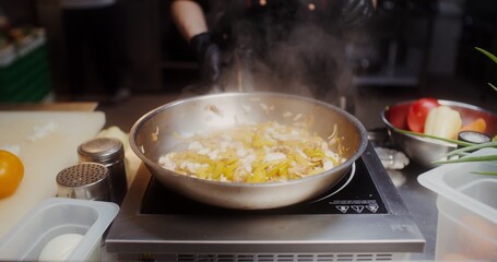 A woman in disposable black gloves adds spices to frying in a frying pan food, close-up of her hands, no face