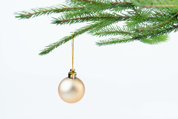 Single gold Christmas glass ball hanging from a pinay brunch, isolated on the white.