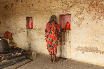Indian woman praying in a small hindu temple in Varanasi