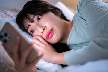 寝る前にスマホに夢中になる日本人女性