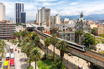 Fototapeta premium Medellin skyline with Metro de Medellín train at Plaza Botero in Medellin, Colombia