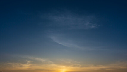 blue sky with soft wispy clouds at sunrise