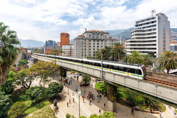 Medellin skyline with Metro de Medellín train at Plaza Botero in Medellin, Colombia