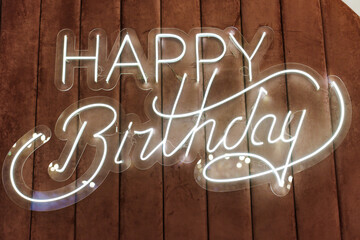 Happy Birthday inscription made of LED strip on a velvet soft surface.