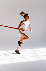 Young female athlete training in a gym using sport equipment