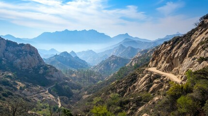 Fototapeta premium Serene Landscape of Mountains and Winding Dirt Road Under Blue Sky
