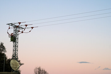 Small electric tower in hydroelectric power station with light background with cables crossing horizontally