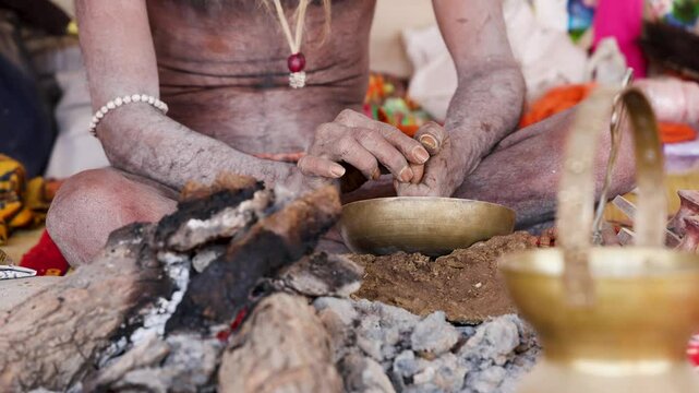 spiritual naga sadhu filling marijuana in pipe during mahakumbh festival