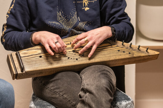 Fingers of a girl playing kankles, Lithuanian plucked string instrument belonging to the Baltic box zither family known as the Baltic psaltery, in Latvian kokles, Estonian kannel, Finnish kantele