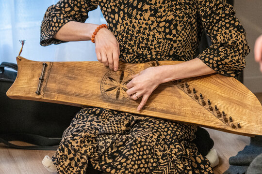 Fingers of a girl playing kankles, Lithuanian plucked string instrument belonging to the Baltic box zither family known as the Baltic psaltery, in Latvian kokles, Estonian kannel, Finnish kantele