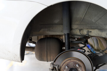 Shock absorber broken. Close up of car rear suspension system, showing shock absorber, coil spring, and brake disc