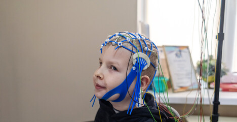 A boy's brain is examined on an EEG machine. Electroencephalogram is performed in a hospital...
