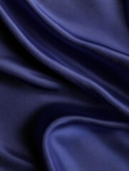Close up of smooth, royal blue fabric. Light creates soft shadows across the folds and curves
