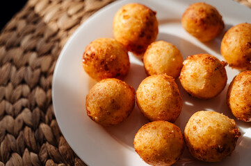 Homemade cottage cheese donuts on a white plate, illuminated by warm sunlight, creating a cozy and appetizing scene