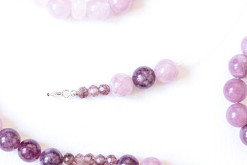 Preparing gemstone jewelry. Natural stones pink quartz, Amethyst, silver. Craft, handmade conception. Free space for text.