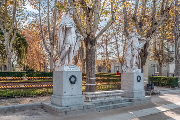 Fototapeta premium Statues of Suintila and Leovigildo, two historic kings of Spain, in Plaza de Oriente, Madrid. These marble sculptures are surrounded by autumn trees. Madrid, Spain - November 30, 2021
