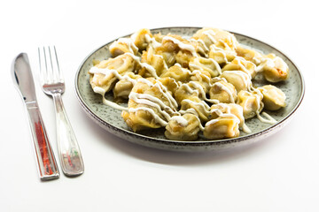 Homemade dumplings with fried onions on white background. Food concept