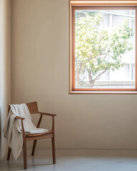 Fototapeta premium Cozy interior with wooden chair and large window showcasing a tree outside during daytime