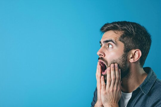 Portrait studio d&rsquo;un homme choqu&eacute; sur fond color&eacute; bleu