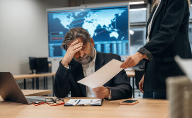 More paper work, boring, tired. Senior man is in the office with employee
