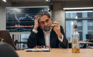Drinking alcohol, depression. Senior man is in the modern office
