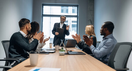 Meeting, sitting by the table. Group of office workers are indoors together