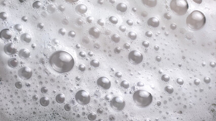 White cream foam with gentle waves and bubbles. Soothing and clean aesthetic. Abstract white soap foam bubbles texture background.