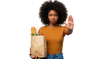 A young woman with curly hair stands holding a brown grocery bag filled with vegetables. She gives a stop gesture with her hand, expressing disapproval or refusal