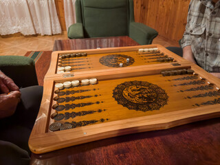 Backgammon board during intense game between two senior people