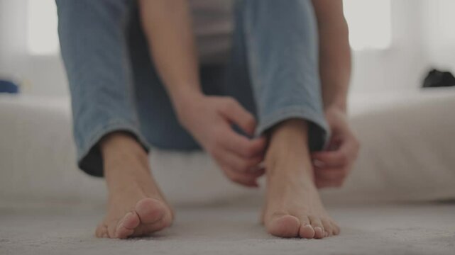 Close-up of a guy putting on black socks.Young guy putting on socks.Camera stable motion.4k video.A schoolboy puts on a green and white sock on his feet
