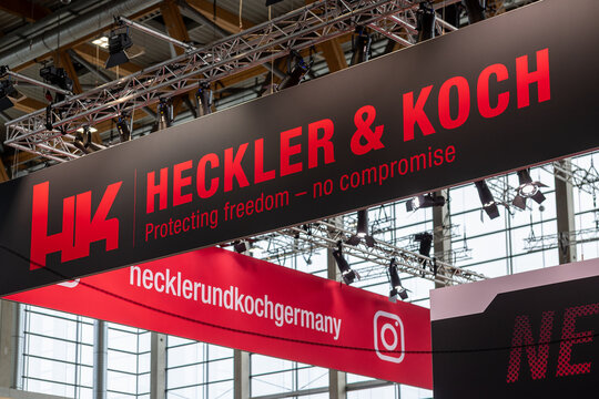 Messestand von Heckler & Koch mit gro&szlig;em, beleuchtetem Firmenlogo und dem Slogan &bdquo;Protecting freedom &ndash; no compromise&ldquo;. 