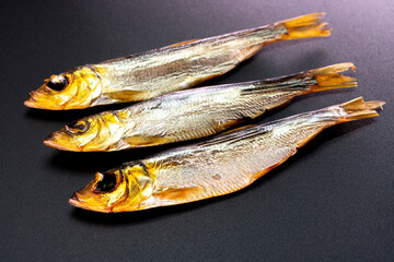 Hot smoked whole herrings on kitchen table. smoked fish isolated on a black background