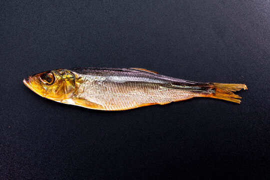 Hot smoked whole herrings on kitchen table. smoked fish isolated on a black background