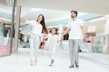 Family, father, mother and daughter are walking to another store in shopping mall.
