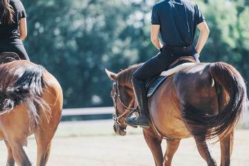 Two riders on horseback enjoy a tranquil ride outdoors. The image captures the essence of...