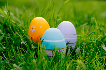Happy Easter. Easter eggs on grass on a sunny spring day - Easter decoration, banner, panorama, background with copy space for text.