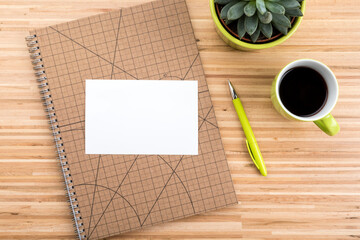 Wooden desk with ring binder, coffee cup, succulent plant  and copy space on blank paper