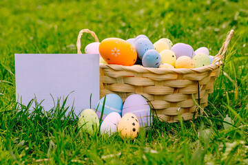 Happy Easter. Basket with Easter eggs in grass on a sunny spring day - Easter decoration, banner, panorama, background with copy space for text