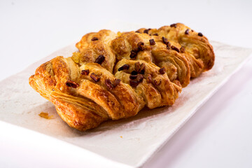 Fresh delicious puff pastry with maple syrup and nuts on white background